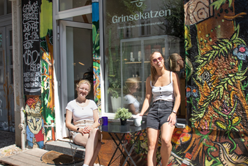 CBD-Shop: Grinsekatzen Ebertystr. 31, 10249 Berlin von außen mit Mitarbeiterinnen - GRINSEKATZEN® - Dein CBD Shop